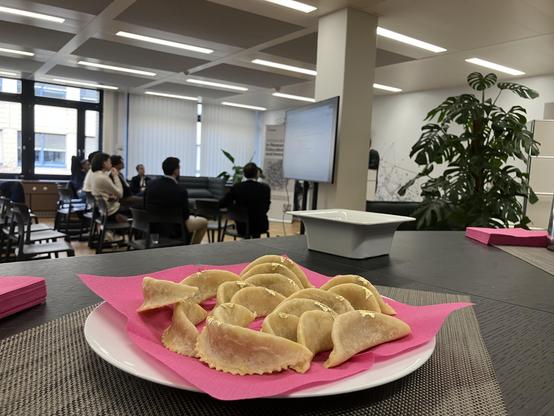 A Maroccan delicacy (brought in by Jocelyne) with a workshop of people sitting in a roundtable in the background.