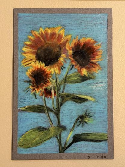 Oil pastel drawing of sunflower. They are drawn on a brown gray paper. Three flowers face the viewer. Their petals range from very dark browns in the middle to bright yellows at the tips. There is one just opened flower facing away from the viewer and one flower bud visible from the side. Background is sky blue with darker blues and whites peeking through.