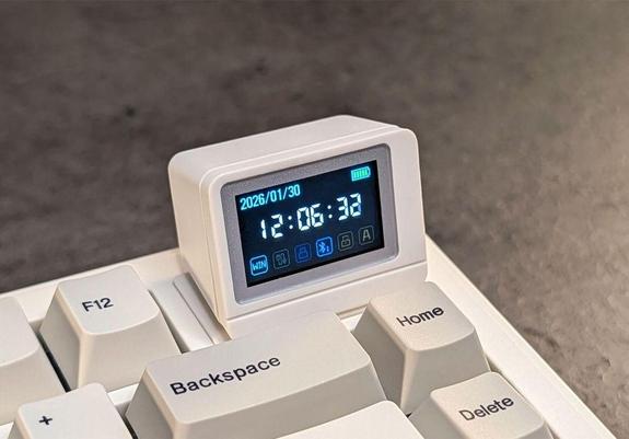 A small digital display on a gray keyboard, showing the date, time, battery and status icons.