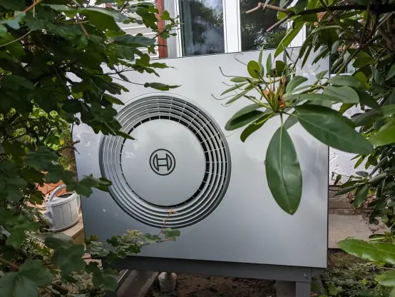 Eine Wärmepumpe im Gebüsch. (Foto: Birgit Höfer)