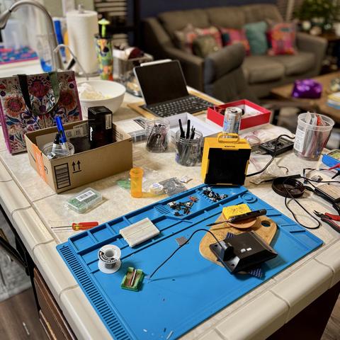 Kitchen counter littered with electronics soldering equipment.