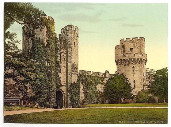 This image depicts a historic castle with notable architectural features. The structure showcases classic medieval design, including stone towers and battlements that suggest defensive fortifications from the past centuries. One tower stands prominently in the foreground, adorned with climbing ivy which adds to its aged appearance. A clock is visible on this tower, indicating both timekeeping functionality and a decorative element typical of such structures.

The castle's architecture includes round turrets and arched entryways that are characteristic of medieval European castles built for defense as well as residence or governance. The surrounding environment features manicured green lawns indicative of upkeep and possibly functioned as grounds for the estate, suggesting it might still be in use today despite its historical significance.

The image appears to be an old photograph, given its sepia-toned coloration which is common in early 20th-century print media. This particular photo was taken or published around the turn of the century, between approximately 1890 and 1900, as indicated by a date code at the bottom right corner.

The identification "THE WARWICK CASTLE" confirms that this is Warwick Castle in England, known for its long history dating back to Roman times. The castle has served various roles over centuries—from fortress to residence—and continues to be a  [...]
