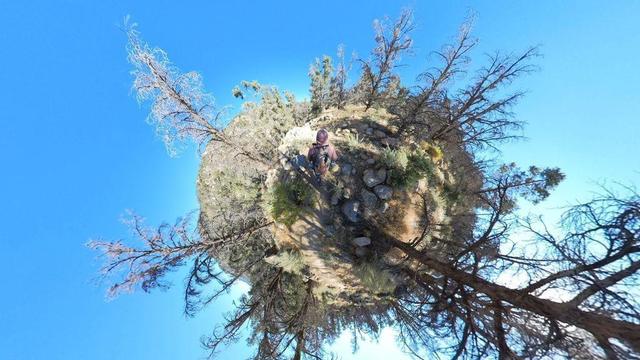 One of a series of clear-blue-sky summertime photos showing a person hiking through the South Sierra Wilderness in central California. The dry, rocky, mountainous terrain features pinyon pine and juniper woodlands, and the occasional cactus.