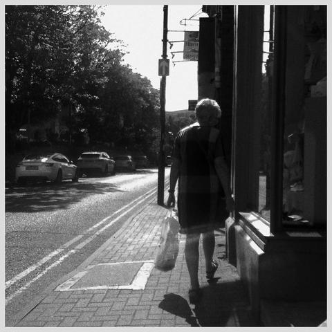 Street photo of a woman walking.