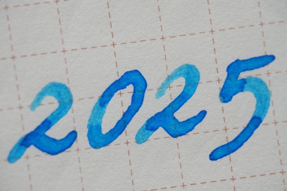 "2025" written in text figures, written in sky blue ink showing ink shading