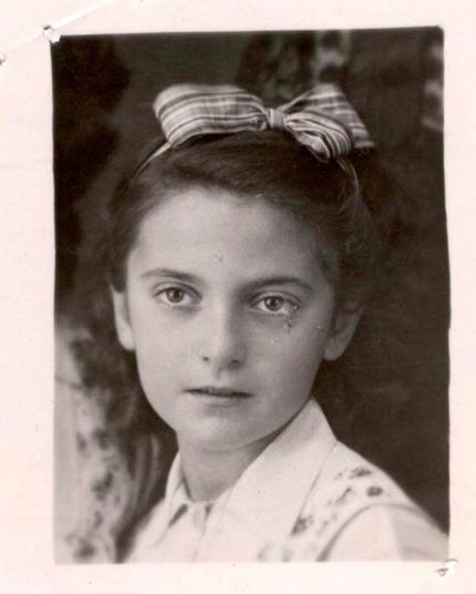 Black and white portrait of a young girl with a bow in the hair.