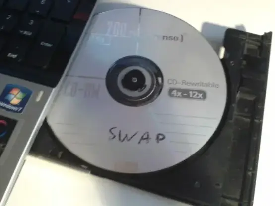 CD-RW labeled SWAP inside of opened laptop's cd-drive