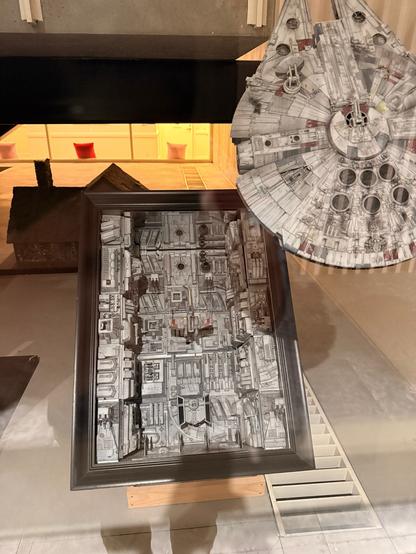 Model of Millennium Falcon and a segment of the Death Star trench with a tiny Xwing flying through