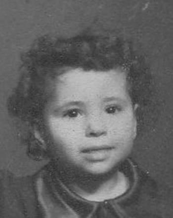 Black and white portrait of a young girl with curly hair, looking directly at the camera.