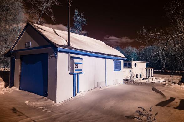 a infrared picture from my converted camera of the yellow and blue garage and white houseboat, which shows up differently in this picture taken at approximately 690nm.