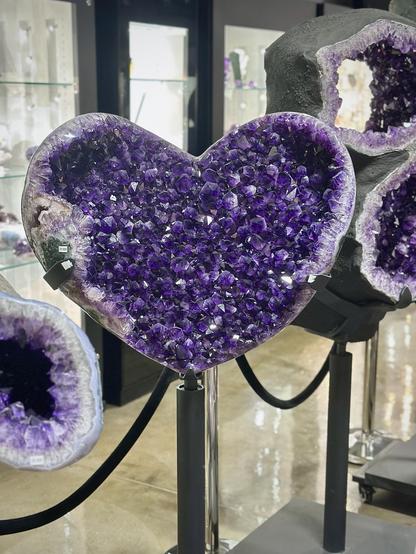Same location as previous photo this geode is a bit wider and more distinctly heart-shaped. About 36” wide and 28” tall. This geode also has some green malachite on the left at the edges it’s not the same specimen. There were about 19 enormous geodes in this part of the gallery, all on heavy black stands with black decorative rope defining the area.