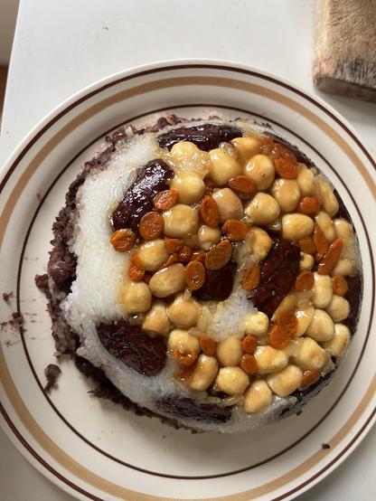 Chinese glutinous rice dessert or 八宝饭。 up-side down rich cake with lotus seed, Chinese dates on top and a layer of red bean paste in between. Steamed in a bowl so bowl shaped.