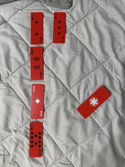 The starting configuration of a game of Osmosis solitaire played with slim red AirDeck playing cards.