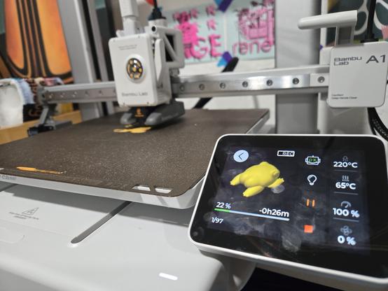 A model of a yellow frog with a humanoid butt on the screen of a 3D printer happily printing