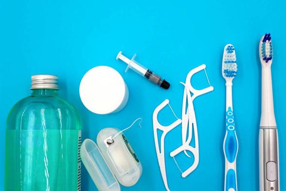 essential oral hygiene products on blue background