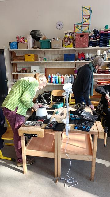 People repairing in  little school working tables