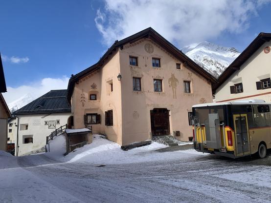 Typische Häuser mit Sgraffiti in Guarda, dem Dorf mit dem Schällenursli-Museum. Links, etwas abgeschnitten, das kleine Postauto, welches von der Bahnstation auf halber Höhe im Tal hinauffährt und sehr gut besetzt war.