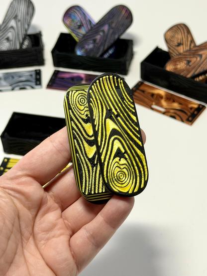 New kickflips in a wood grain/Damascus finish. Gold silk is pictured in hand, also available in silver, bronze, and iridescent (RGB).