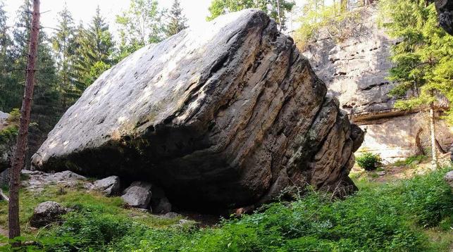großer Quadratischer Felsbrocken liegt umgekippt in der Waldlandschaft der sächsischen Schweiz