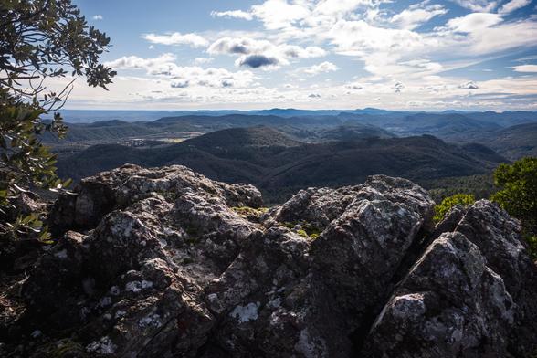 un promontoire de roche calcaire donnant vue sur une vaste étendue cévenole de montagnes et collines verdoyantes