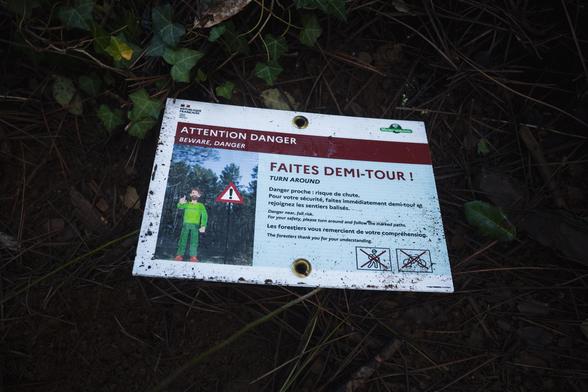 Un panneau de l’ONF tombé à terre stipule : 

"ATTENTION DANGER FAITES DEMI-TOUR! Danger proche : risque de chute. Pour votre sécurité, faites immédiatement demi-tour et rejoignez les sentiers balisés. Les forestiers vous remercient de votre compréhension.”