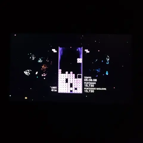 Foto alla console in mezzo alla partita, al buio; lo schermo della console appare quasi perfettamente fuso con il resto del campo visivo, come detto