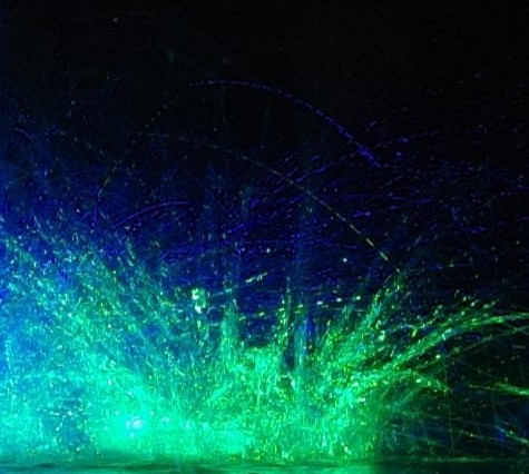 A heavy transport driver failed to lower a crane properly and damaged a motorway bridge with drainage pipes. This caused waterfalls that form ed large drops that shattered on the asphalt again. I managed to capture two of them, which hit almost simultaneously, right next to each other. I was patient and, by chance, had green and blue lights with me (which you need when cycling;).