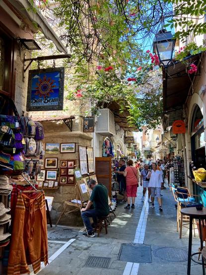 Belebte enge Gassen mit vielen Verkaufsläden, Menschen und grünem "Himmel".