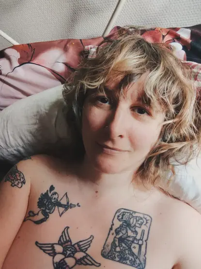 Selfie d'une meuf blonde allongée dans son lit.