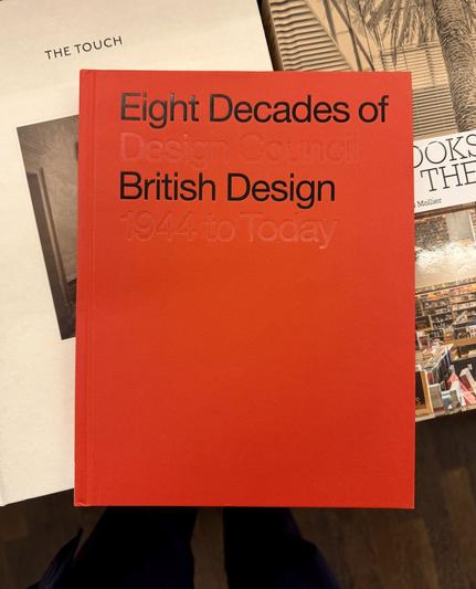 A red book with plain typography reading “Eight Decades of British Design: Design Council 1944 to Today” — with the second part blind embossed, while the first is black on red
