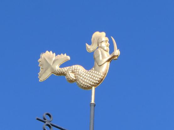 A gilded weathervane of Neptune, represented by a merman with a sword