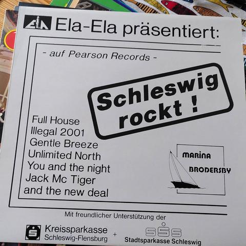 Ein weißes Plattencover, der Titel lautet " Ela-Ela Präsentiert, Schleswig Rockt: Full House, Illegal 2001, Gentle Breeze, Unlimited North,  You and the night, Jack Mc Tiger and the new Deal