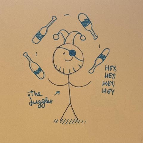 Dijo de muñeco palo en el papel de malabarista, con su malabares, su gorrito de malabarista y su parche. El cuerpo está en negro y los detalles en azul. Al lado aparecen dos textos uno con «The Juggler» y otro con «Hey, hey, hey, hey».