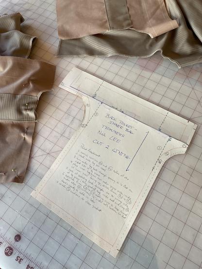 Pattern piece for a back pocket with detailed instructions for construction written on it.