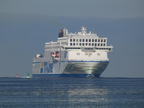 Die TT-Line (Fähre) fährt nach Warnemünde ein. Ein großes Fährschiff, man sieht den Bug auf der See. Spiegelung im Wasser. Bojen.