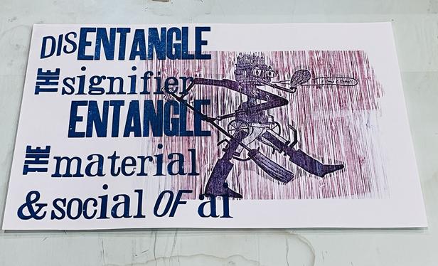 Photo of a letterpress print on white paper with overlapped blue and red inks for an image of a marching historical automaton armed with broom, saying "I come, I come!". The whole has a vertical bamboo woodgrain, like rain. Blue text says "Entangle the signifier, entangle the material & social of ai"
