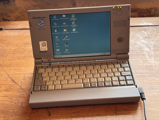 A vintage laptop, Toshiba Libretto 70CT, on a wooden furniture