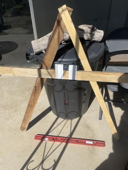 Two pieces of wood with a cross piece to make an "A" shape.  A level is on the ground to confirm a flat surface.  another smaller level is taped to the cross piece.