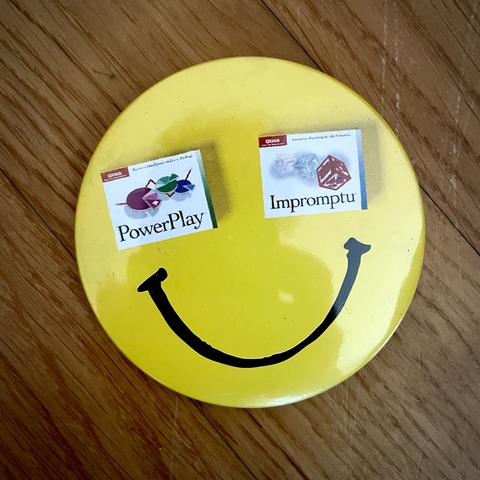 Old school badge with a yellow smiley on it. The eyes are replaced with IBM products PowerPlay and Impromptu