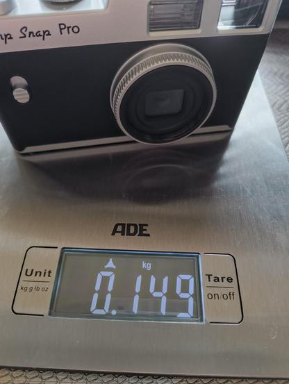 Die Camp Snap Pro Kamera auf der Küchenwaage. Sie wiegt genau 149 Gramm.