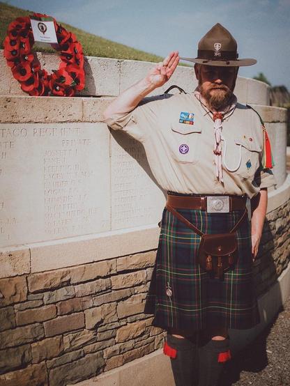 Adult scout—with scouts hat and in MacLaren kilt—making the scout salute