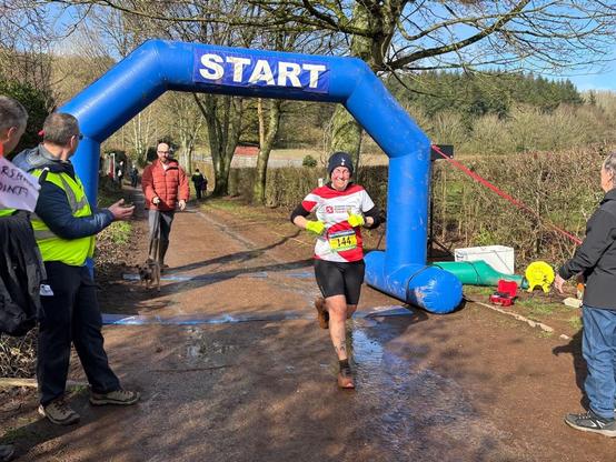 Photo of Emily crossing the finishing line - she is grinning.