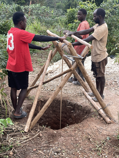 3 men workers standing at the pulley system used to pull out the dig soil