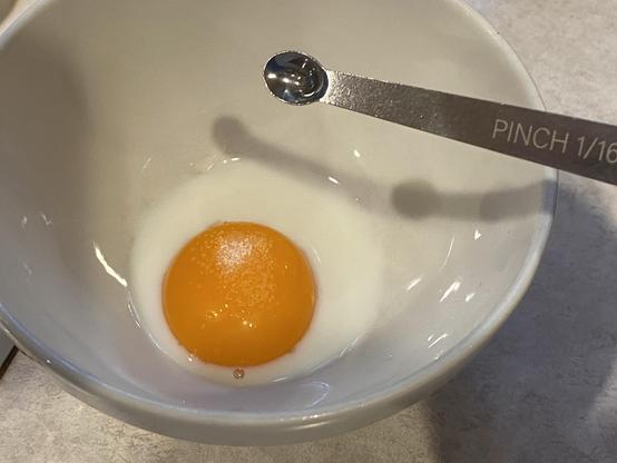 egg, milk, and 1 pinch of salt in a bowl with a tiny measuring spoon labelled “pinch”