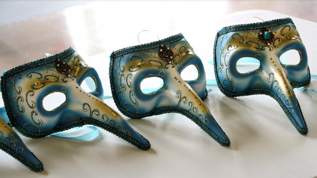 Esta imagen muestra tres máscaras venecianas de estilo "Medico della Peste" (Médico de la Peste) dispuestas en fila sobre una superficie clara. Se caracterizan por su distintiva nariz larga en forma de pico, un diseño que históricamente se utilizaba para albergar sustancias aromáticas con el fin de protegerse de los malos olores durante las epidemias.