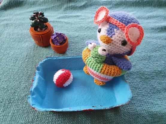 Petit pingouin au crochet avec lunettes de piscine, ballon, bouée à tête de grenouille au crochet, piscine en carton