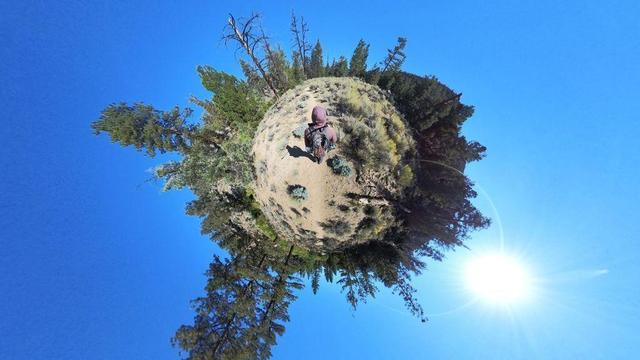 One of a series of clear-blue-sky summertime photos showing a person hiking through the South Sierra Wilderness in central California. The dry, rocky, mountainous terrain features pinyon pine and juniper woodlands, and the occasional cactus.