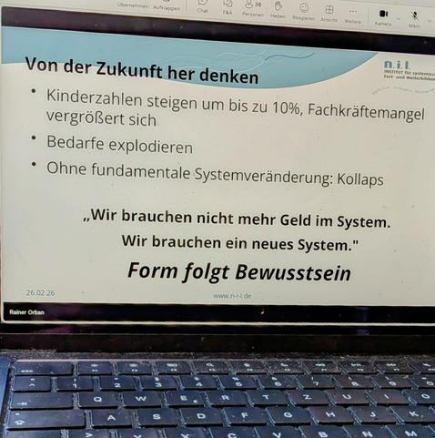 Folie mit dem Text "Wir brauchen nicht mehr Geld im System. Wir brauchen ein neues System!"