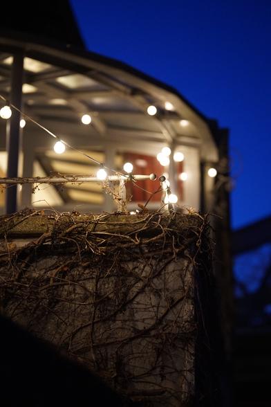Lichterkette über einer Mauer spät am Abend