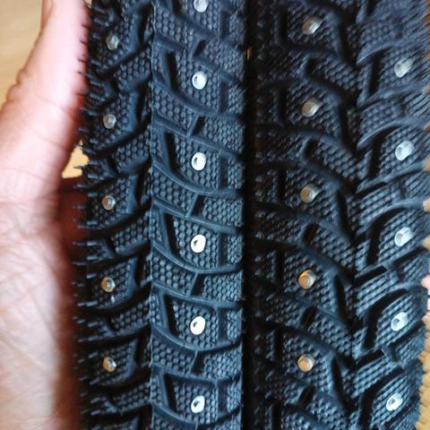 Etwas unscharfes Foto. Ich halte mit der Linken zwei Radreifen mit metallenen Spikes.